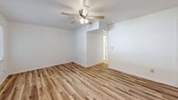 Located at 821-831 Sleepy Hollow Rd in Pittsburgh, PA, this 2-bedroom unit offers a practical and well-appointed layout across a single floor. Warm, light-toned hardwood-style flooring runs throughout the entire space, creating a cohesive and inviting atmosphere in every room.

The spacious primary bedroom is a standout feature, offering generous room for furnishings and accented by a ceiling fan with integrated lighting. A stylish sliding barn door leads to the closet, adding a modern touch to the space. The second bedroom also includes a ceiling fan, a window with natural light, and a floor vent for climate control, keeping the room comfortable year-round.

The kitchen is efficiently designed with crisp white cabinetry, granite-look countertops, a stainless steel sink, and a full-size refrigerator. A window above the counter brings in natural light, enhancing the clean, bright aesthetic of the space.

Additional highlights include a dedicated laundry area, clean white walls throughout, and a functional layout that connects the rooms with ease. The consistent flooring and neutral palette create a bright, move-in-ready environment well-suited for everyday living in the Pittsburgh area.