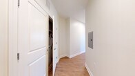 This single-floor residence offers a thoughtfully designed layout that balances open communal areas with comfortable private spaces. The heart of the unit is an open-concept kitchen and living area, where hardwood-style flooring runs throughout. The kitchen features a central island with a granite countertop, an integrated sink, and pendant lighting overhead. Two-tone cabinetry—white uppers paired with gray lowers—complements a full suite of stainless steel appliances, including a refrigerator, gas range, and microwave. A subway tile backsplash adds a clean, contemporary detail. Large windows along the living area admit abundant natural light and offer views of the surrounding neighborhood.

The bedrooms are carpeted for comfort, each featuring a closet and windows that continue the unit's bright, airy feel. The primary bathroom includes a double vanity with granite countertops, white cabinetry, and a large mirror, while a secondary full bathroom offers tile flooring and a shower-tub combination. A dedicated utility area houses the in-unit washer and dryer, adding everyday convenience. A hallway with an electrical panel connects the private areas of the unit. Clean white walls, consistent trim work, and neutral finishes throughout create a cohesive and move-in-ready environment.