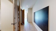 Located at 301 12th Ave in Seattle's vibrant Capitol Hill neighborhood, this efficiently designed single-floor unit makes smart use of its intimate footprint. Light hardwood-style flooring runs throughout the main living area and entryway, lending a clean, cohesive aesthetic to the space.

The kitchen is a standout feature, boasting a full run of sleek charcoal cabinetry — both upper and lower — paired with white countertops and stainless steel appliances, including a refrigerator, electric range, and dishwasher. Track lighting overhead ensures the kitchen is well-illuminated, and a ventilation hood adds a functional, modern touch.

The bathroom is designed with accessibility in mind, featuring a spacious layout, speckled vinyl flooring, a wall-mounted grab bar, and a bathtub with a shower. Neutral walls and clean fixtures give it a fresh, utilitarian feel.

A dedicated living and sleeping area offers a calm, open environment with recessed lighting, a sliding closet with warm wood-toned doors, and a wall-mounted heater. The space receives natural light from a large window, contributing to a bright and airy atmosphere. The entryway corridor, with recessed lighting and clean white walls, provides a welcoming transition into the unit.