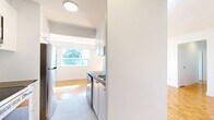 Located at 110 Park Road North in Oshawa, Ontario, this well-laid-out 3-bedroom, 1-bathroom unit offers a comfortable and functional living space across a single floor. Warm parquet flooring runs consistently throughout every room, lending a cohesive and classic character to the interior.

The expansive living room is a standout feature, bathed in natural light from a large picture window and sliding glass doors that open onto a private balcony with open views of the surrounding neighbourhood and greenery. The kitchen is conveniently positioned adjacent to the living and dining area, featuring white cabinetry, subway tile backsplash, and stainless steel appliances including a full-size refrigerator.

Three well-proportioned bedrooms line the unit, each featuring bright windows with outdoor views, clean white walls, and the same warm parquet flooring. The primary bedroom is generously sized and includes a sliding door closet. Additional bedrooms offer ample natural light and closet or storage access via hallways.

The full bathroom is finished with classic white subway tile surrounding a full soaker tub and shower combination, chrome fixtures, and neutral tile flooring, creating a clean and timeless aesthetic. Two hallways and a dedicated closet provide practical storage and smooth circulation throughout the unit.