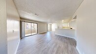 Located at 5150 E Sahara Ave in Las Vegas, NV, this single-floor, 3-bedroom, 2-bathroom residence offers a well-organized and functional layout. The open-concept living and dining area is bright and welcoming, featuring light-toned wood-look flooring, neutral warm-beige walls, and a textured ceiling throughout. Large sliding glass doors lead to a private balcony, allowing natural light to pour into the main living space, while an arched window adds a distinctive architectural touch near the entrance.

The kitchen flows naturally from the dining area and is equipped with white cabinetry, a range, dishwasher, and refrigerator, alongside light countertops that keep the space feeling clean and bright. A peninsula-style counter separates the kitchen from the living area, enhancing the open feel.

Each of the three bedrooms features the same wood-look flooring and neutral tones, offering a calm and versatile space. The bedrooms are served by dedicated closets, including sliding-door wardrobe closets. The primary bedroom is a comfortable, well-proportioned retreat.

The two bathrooms are finished with white vanities, light countertops, and mirrors. One bathroom conveniently incorporates a laundry area. Additional highlights include a utility room, hallway, and dedicated entrance, rounding out a practical and comfortable home.