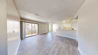 Located at 5150 E Sahara Ave in Las Vegas, NV, this single-floor, 3-bedroom, 2-bathroom residence offers a well-organized and functional layout. The open-concept living and dining area is bright and welcoming, featuring light-toned wood-look flooring, neutral warm-beige walls, and a textured ceiling throughout. Large sliding glass doors lead to a private balcony, allowing natural light to pour into the main living space, while an arched window adds a distinctive architectural touch near the entrance.

The kitchen flows naturally from the dining area and is equipped with white cabinetry, a range, dishwasher, and refrigerator, alongside light countertops that keep the space feeling clean and bright. A peninsula-style counter separates the kitchen from the living area, enhancing the open feel.

Each of the three bedrooms features the same wood-look flooring and neutral tones, offering a calm and versatile space. The bedrooms are served by dedicated closets, including sliding-door wardrobe closets. The primary bedroom is a comfortable, well-proportioned retreat.

The two bathrooms are finished with white vanities, light countertops, and mirrors. One bathroom conveniently incorporates a laundry area. Additional highlights include a utility room, hallway, and dedicated entrance, rounding out a practical and comfortable home.