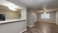 This single-floor, 2-bedroom, 2-bathroom residence offers a practical and cohesive layout designed for comfortable everyday living. Wood-look vinyl plank flooring runs throughout the home, complemented by neutral gray walls and white trim that create a clean, consistent aesthetic. Textured ceilings are featured in every room, and ceiling fans with light kits are installed in the living area and both bedrooms, providing both airflow and ambient lighting.

The entrance opens into a spacious living room, which receives natural light through a front-facing window. Adjacent to the living room is the kitchen, connected via a pass-through counter with light stone-look surfaces. The kitchen is equipped with black appliances — including a refrigerator, electric range, over-the-range microwave, and dishwasher — alongside ample white cabinetry and a double-basin sink.

The primary bedroom offers generous proportions with a walk-in closet and direct access to its own bathroom, which includes a tub/shower combination. The second bedroom is well-sized, also featuring a ceiling fan and a closet. A second full bathroom with a tub/shower combo serves the rest of the home. A dedicated hallway connects the bedrooms and bathrooms, providing a logical and private flow throughout the residence.