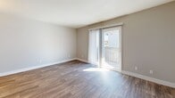 Located at 2606 N 44th St in Phoenix, Arizona, this 2-bedroom, 2-bathroom residence offers a well-organized single-floor layout designed for comfortable everyday living. The living area features durable wood-style flooring and neutral gray walls that create a clean, modern aesthetic. A sliding glass door opens to a private balcony, allowing natural light to fill the space and providing a seamless indoor-outdoor connection.

Both bedrooms are finished with plush wall-to-wall carpeting and painted in soft, neutral tones. Each bedroom includes an open closet with built-in shelving and hanging rods, offering practical storage solutions. The primary bedroom is a comfortable size and provides direct access to its own bathroom. Windows in the bedrooms invite natural light and outdoor views.

The two bathrooms are consistently finished with wood-look flooring, white tub-shower combinations, and dark-toned vanities topped with light countertops, lending a contemporary contrast to the clean white fixtures. The overall design throughout the residence emphasizes a cohesive, neutral palette, making it a versatile and move-in ready space in the heart of Phoenix.
