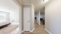 This single-floor residence offers 2 bedrooms and 2 bathrooms within a thoughtfully designed layout. A welcoming hallway with light wood-style flooring and crisp white trim leads into the main living areas, where crown molding and a textured ceiling add classic detail. The living room is open and airy, featuring a ceiling fan and ample space for relaxing or entertaining.

The kitchen is well-equipped with white cabinetry, granite countertops, a stainless steel under-mount sink, and stainless steel appliances including a dishwasher — combining style with practicality. A combined kitchen and living room area enhances the open-concept feel of the home.

The primary bedroom is generously sized with plush carpeting, natural light streaming through windows, and direct access to its own bathroom. The en-suite bathroom features a white vanity with a rounded basin sink and a shower-tub combination. The second bedroom is also carpeted and well-lit. A dedicated closet provides additional storage.

Throughout the home, neutral gray walls, white millwork, and consistent wood-style flooring in the common areas create a cohesive and clean aesthetic. Corner windows in one area flood the space with natural light and outdoor views, enhancing the overall bright and comfortable ambiance of this functional residence.