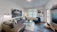 This contemporary 650 square foot apartment in Maplewood, MO, offers a harmonious blend of style and functionality. The open-concept layout maximizes space, creating a seamless flow between the living areas. The kitchen is a standout feature, boasting dark wood cabinetry, stainless steel appliances, and granite countertops. An island with seating adds versatility and extra workspace.

The living room is bathed in natural light from large windows, complemented by modern furnishings and artistic wall decor. Hardwood-style flooring runs throughout, adding warmth and continuity. The spacious 120 square foot bedroom features a plush bed, ample closet space, and continues the apartment's sleek design aesthetic.

Attention to detail is evident in the carefully chosen color palette, lighting fixtures, and decorative elements. The bathroom, while not pictured, likely maintains the same level of modern finishes. This unit, part of a larger complex, offers a perfect balance of comfort and contemporary urban living in its single-floor layout.