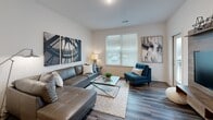 Located at 31 Sunnen Drive in Maplewood, Missouri, this one-bedroom unit offers a well-designed, single-floor layout that maximizes every inch of its compact footprint. The open-concept floor plan seamlessly connects the kitchen and living room, creating a cohesive and functional living space bathed in natural light from large windows fitted with blinds.

The kitchen is a standout feature, showcasing rich dark-wood cabinetry that extends to the ceiling, granite countertops, and a full suite of stainless steel appliances including a refrigerator, range, microwave, and dishwasher. A central island with granite surface and bar seating serves as both a prep area and casual dining spot, anchoring the kitchen to the open living area.

The living room is bright and welcoming, with hardwood-style plank flooring that flows throughout the unit, neutral walls, and ample space for comfortable furnishings. Natural light pours in through a large window, enhancing the airy ambiance.

The bedroom is a quiet retreat, comfortably sized to accommodate a queen or king bed, and features its own window for natural light, a ceiling fan, and direct access to a dedicated closet. The hardwood-style flooring continues here, maintaining a consistent aesthetic across the unit.

Track lighting in the kitchen, clean white walls, and modern finishes throughout contribute to a polished, contemporary feel well-suited for everyday living.