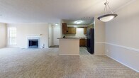 Located in Birmingham, Alabama, this single-floor residence at 6502 Colony Park Dr offers a well-organized, open-concept layout designed for comfortable everyday living. The main living area is generously proportioned, featuring plush carpeting, crown molding, and a classic fireplace that serves as a focal point. Large windows along one wall frame lush, tree-lined views, filling the space with natural light and creating a warm, inviting ambiance.

The kitchen is positioned adjacent to the living area and features warm-toned wood cabinetry, granite-style laminate countertops, a double-basin stainless steel sink, a black dishwasher, and a black refrigerator. A peninsula counter connects the kitchen to the main living space, offering additional workspace and a natural transition between areas. Hard surface flooring runs throughout the kitchen for easy maintenance.

Multiple carpeted bedrooms provide comfortable, quiet retreats, each with neutral wall tones and windows fitted with blinds that allow for natural light and privacy. Textured ceilings are consistent throughout the home.

The bathroom includes a wood-toned vanity with a granite-style countertop, a medicine cabinet with louvered doors, a combination tub and shower, and durable wood-look flooring. The overall aesthetic of the residence is clean, neutral, and functional, making it a practical and comfortable home in the Colony Park community.