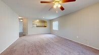 Located at 7501 Ulmerton Rd in Largo, Florida, this single-floor unit offers a well-organized and functional layout designed for comfortable everyday living. The spacious living area is outfitted with plush carpeting, a ceiling fan with light fixture, and a large window fitted with vertical blinds that allow ample natural light to fill the room. A glass-paneled door provides direct access to an outdoor area with views of surrounding greenery. An elegant arched pass-through connects the living area to the kitchen, which features white cabinetry with silver hardware, light-toned laminate countertops, a full suite of appliances including an electric range with overhead ventilation hood, and hardwood-style flooring. The bedrooms are generously sized, each carpeted and equipped with closet storage. One bedroom benefits from a large window with views of the landscaped exterior. The hallway area includes louvered closet doors and leads to the bathrooms. One bathroom features a full soaking tub with white tile surround and chrome fixtures, while another includes a walk-in shower with built-in shelving and a bench seat. Clean neutral tones and consistent finishes throughout contribute to a cohesive and move-in-ready atmosphere.