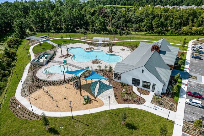 St. Cloud, FL, Houses for Rent - Ibis Park at Harmony West - Aerial View of Resort-Style Pool with Sundeck and Surrounding Greenery. - Ibis Park at Harmony West