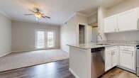 Located at 3331 Luella Blvd in La Porte, TX, this one-bedroom, one-bathroom unit offers a well-designed single-floor layout with thoughtful finishes throughout. The kitchen is a standout feature, boasting granite countertops, white shaker cabinetry, and a full suite of stainless steel appliances including a refrigerator, electric range, over-the-range microwave, and dishwasher. A peninsula with a single-basin sink provides additional workspace and casual dining potential, all set atop wood-look plank flooring. The open living area flows naturally from the kitchen and is bathed in natural light from a set of French doors fitted with classic white shutters. A ceiling fan adds comfort to the space. The bedroom is carpeted, featuring a ceiling fan, a window with exterior views, and access to two closets for ample storage. The bathroom includes a full tub and shower combo with white tile surround and wood-look flooring. A dedicated in-unit laundry area accommodates a full-size side-by-side washer and dryer. Crown molding and neutral tones throughout lend a clean, cohesive aesthetic to the entire space.