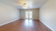 Located at 1334 Pascagoula St in Pascagoula, Mississippi, this two-story, two-bedroom, two-bathroom home offers a practical and comfortable layout spread across two floors. The main level features a welcoming living room with rich hardwood-style flooring, a ceiling fan, and French doors that flood the space with natural light and provide outdoor views. The adjacent kitchen is well-equipped with warm honey-toned wood cabinetry, dark laminate countertops, a double stainless steel sink, a white electric range, and a full-size refrigerator. Light tile flooring and a window with blinds complete the functional cooking space. Upstairs, both bedrooms are finished with soft wall-to-wall carpeting and ceiling fans. The spacious primary bedroom features a large window overlooking greenery, while the second bedroom includes a closet with a folding door. One bedroom also benefits from a vaulted roofline, adding architectural character. One bathroom features a white vanity with an overhead storage cabinet, tile flooring, and a mirror, while the second bathroom offers a full soaking tub with a clean white surround. A dedicated closet provides additional storage. Neutral tones throughout create a calm and cohesive atmosphere across both levels.