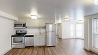 This efficiently designed 1-bedroom, 1-bathroom unit offers a thoughtful layout across a single floor, making excellent use of its space. The kitchen is outfitted with a full suite of stainless steel appliances, including a refrigerator, electric range, over-the-range microwave, and dishwasher. Crisp white shaker-style cabinetry pairs with light quartz countertops to create a clean, modern aesthetic, all set atop warm hardwood-style flooring that flows seamlessly throughout the living areas. Flush-mount lighting fixtures illuminate the open kitchen and living area, which benefits from natural light through well-positioned windows. The bathroom features a full tub-shower combination clad in glossy grey subway tile, complemented by large-format tile flooring, a white vanity with a stone-topped counter, and neutral wall tones that create a calm, spa-like atmosphere. The generously sized bedroom offers two windows that invite natural light, hardwood-style flooring, and a spacious walk-in closet with dual hanging rods, providing ample storage. Hallways connect each room efficiently, contributing to the unit's practical and comfortable flow. The overall design is modern, clean, and move-in ready.