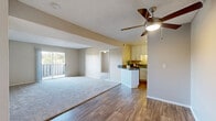 Located in Escondido, California, this 3-bedroom, 2-bathroom residence offers a well-designed single-floor layout that makes efficient use of its space. The open-concept living and kitchen area forms the heart of the home, where wood-look flooring flows seamlessly underfoot and a ceiling fan adds both style and comfort. The kitchen is outfitted with crisp white cabinetry, dark countertops, stainless steel appliances including a range and refrigerator, and a peninsula that provides added prep space and casual dining. The living room extends toward a sliding glass door that opens to a private balcony, offering pleasant outdoor views and natural light. Each of the three bedrooms features plush wall-to-wall carpeting, neutral warm-toned walls, and windows that bring in natural light. The primary bedroom includes a ceiling fan and its own access to the outdoors via a sliding glass door. The two bathrooms are functional and clean in design, each featuring wood-look flooring, with one offering a shower-tub combination. A hallway connects all rooms, providing a logical and practical flow throughout the residence. Textured ceilings are consistent throughout, contributing to the home's cohesive character.