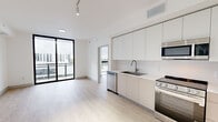 Located at 1155 NE 126th St in North Miami, FL, this modern 2-bedroom, 2-bathroom residence offers a thoughtfully designed open-concept layout across a single floor. Light wood-tone flooring flows consistently throughout the space, complementing the clean, contemporary aesthetic defined by bright white walls and abundant natural light.

The kitchen is a standout feature, outfitted with flat-front white cabinetry extending to the ceiling, stainless steel appliances including a range, microwave, dishwasher, and refrigerator, as well as white countertops and a undermount sink. The kitchen opens seamlessly into the living area, which features floor-to-ceiling sliding glass doors that lead to a private balcony with views of the surrounding North Miami neighborhood.

Both bedrooms are well-proportioned, with the primary bedroom offering a comfortable footprint and a dedicated closet with built-in shelving. Each bedroom benefits from the same consistent light flooring and crisp white walls. The two bathrooms are finished to a modern standard, featuring large-format tile flooring, walk-in showers with textured tile surrounds and brushed gold fixtures, floating wood-toned vanities with white countertops, and illuminated LED mirrors. The overall ambiance is clean, bright, and contemporary throughout.