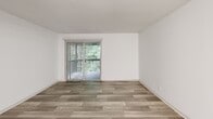 Located at 4831 Summit Cir in Knoxville, TN, this one-bedroom, two-bathroom unit offers a well-organized single-floor layout that makes efficient use of its space. The living area features light wood-look plank flooring, crisp white walls, and a textured ceiling, with a sliding glass door fitted with vertical blinds that opens to a private balcony overlooking lush greenery. A modern chandelier adds a touch of character to the open living and dining area. The kitchen is thoughtfully appointed with gray shaker-style cabinetry, granite countertops, a stainless steel undermount sink, a stainless steel range, and a dishwasher — providing both style and functionality. The bedroom is carpeted for comfort, includes a ceiling fan with lighting, and benefits from natural light through a window with outdoor views. A dedicated walk-in closet provides ample storage directly off the bedroom. Both bathrooms are finished with wood-look tile flooring and granite vanity countertops; one features a full tub-shower combination. Throughout the unit, consistent finishes and a neutral color palette create a clean, cohesive ambiance that is both practical and inviting.