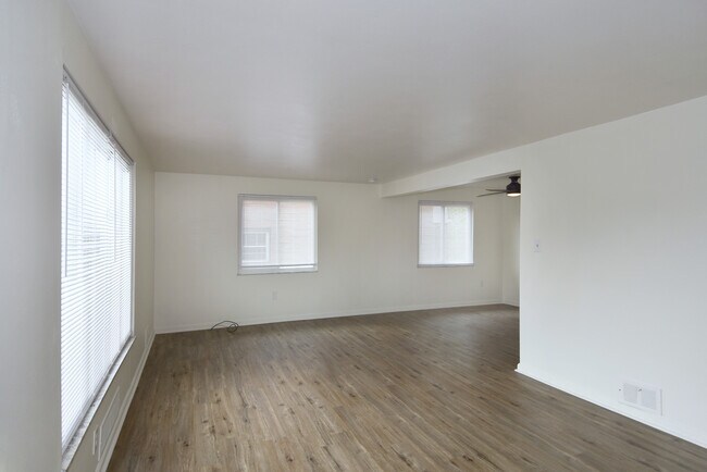 Amplia sala de estar recién pintada con pisos nuevos de tablones de vinilo de lujo y minipersianas en toda la habitación. - 3156 Glendale Ave