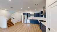 Located at 1716 S Brook Dr in Leander, TX, this two-story home offers a well-designed layout across two floors, combining modern aesthetics with practical functionality. The main level features an open-concept kitchen and living area, where light hardwood flooring flows throughout and recessed lighting creates a bright, welcoming atmosphere. The kitchen is a standout, showcasing bold navy blue shaker-style cabinetry, white quartz countertops, a white subway tile backsplash, stainless steel appliances including a gas range, dishwasher, and French door refrigerator, and a sleek undermount sink. A ceiling fan and large window in the living area invite natural light and comfortable airflow. The upper floor hosts three bedrooms, including a spacious primary suite, and is complemented by four bathrooms in total. The bathrooms feature clean, minimalist finishes with tile flooring and tub-shower combinations. Bedrooms are finished with the same warm hardwood-style flooring, crisp white walls, and modern panel doors with matte black hardware. Storage is well-considered, with closets offering built-in shelving and hanging rods, including a generously sized walk-in closet. The home presents a cohesive, contemporary design throughout.