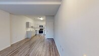 Located at 3113 Pine Orchard Ln in Ellicott City, MD, this 2-bedroom, 1-bathroom residence offers a clean, modern aesthetic throughout its single-floor layout. The open living area flows seamlessly into the kitchen, which is outfitted with gray shaker-style cabinetry, stainless steel appliances including a refrigerator, range, microwave, and dishwasher, and light wood-look luxury vinyl plank flooring that extends through the main living spaces. The living room benefits from a large window that draws in natural light, enhancing the bright, neutral color palette of the interiors. The primary bedroom is generously proportioned, featuring plush carpeting, a ceiling fan, and a window with outdoor views, while a dedicated walk-in closet with wire shelving provides ample storage. The second bedroom also features wood-look flooring and a classic paneled door. The full bathroom is well-appointed with a gray vanity, white countertop, a tiled tub-shower combo, and matching wood-look flooring. A dedicated in-unit laundry area accommodates a full-size washer and dryer, adding everyday convenience. Hallways connect the spaces efficiently, completing this tidy and functional residence.