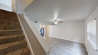Located at 2100 Rebsamen Park Rd in Little Rock, Arkansas, this two-story, four-bedroom home offers a practical and comfortable layout spread across two well-proportioned floors. The main level features an open living room with light wood-style plank flooring, neutral gray-toned walls, and a ceiling fan with integrated lighting. The living area flows directly into a bright kitchen equipped with white shaker-style cabinetry, granite-look countertops, a double sink, and black appliances including a gas range and dishwasher. A window above the sink allows natural light to fill the space. A carpeted staircase connects the two floors, with additional access points for ease of circulation. The upper level houses the bedrooms, including a generously sized primary bedroom, all finished with plush carpet, ceiling fans, and windows that bring in natural light and outdoor views. The full bathroom features wood-style tile flooring, white cabinetry with granite-look counters, and a tub-shower combination. A dedicated closet provides additional storage. Ceiling fans are present throughout the home, contributing to year-round comfort. The clean, neutral palette and updated finishes create a bright, move-in-ready atmosphere throughout.