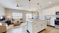 Located in Sandusky, Ohio, this well-appointed two-story home offers a thoughtfully designed layout with modern finishes and a bright, welcoming atmosphere. A clean, light-filled entryway hallway with wood-look flooring and crisp white trim sets the tone upon arrival, guiding you toward the open-concept main living area. The kitchen is a standout, featuring white shaker cabinetry with matte black hardware, quartz countertops, stainless steel appliances, a center island with a double sink, and pendant lighting. A walk-in pantry provides generous storage. The kitchen flows seamlessly into the dining area, which is highlighted by a modern chandelier and a large window overlooking the outdoors, and into the living room, where natural light pours in through multiple windows. The living areas are finished with wood-look luxury vinyl plank flooring. A half bathroom on the main level offers convenience for guests, featuring a pedestal sink and wood-look tile flooring. Upstairs, the bedrooms are carpeted and peaceful, with windows that bring in natural light. The primary bedroom features a comfortable layout with ample room for a full suite. Additional bedrooms reflect the same neutral, calming palette found throughout the home. This residence combines practical design with contemporary style in a desirable Sandusky location.