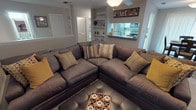 This single-floor, 2-bedroom, 2-bathroom residence offers a thoughtfully designed layout that balances comfort and functionality. The living room serves as the heart of the home, featuring a large sectional sofa, ceiling fan, built-in shelving, and a pass-through window that connects seamlessly to the kitchen — creating an open, social atmosphere. The kitchen is equipped with white shaker-style cabinetry, granite-look countertops, stainless steel appliances, and light wood-tone flooring, complemented by a convenient walk-in pantry for added storage. A dedicated dining area with natural light and elegant window treatments provides an inviting space for meals. The primary bedroom offers plush carpeting, a ceiling fan, sliding glass door access to an outdoor area, and an en-suite bathroom with a wide vanity and large mirror. The second bedroom is equally comfortable, featuring soft carpet, a ceiling fan, and easy access to the second full bathroom, which includes a vanity with ample counter space and medicine cabinet storage. A dedicated laundry area with full-size washer and dryer hookups and overhead cabinetry adds everyday convenience. Neutral tones and consistent finishes create a cohesive, welcoming ambiance throughout the entire space.