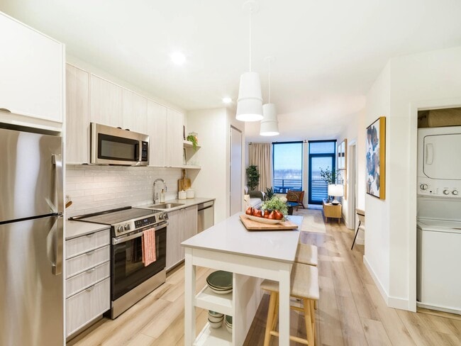 Una cocina abierta con acabados refinados, lavandería dentro de la vivienda y una perfecta integración con la sala de estar. - Modera Revere Beach