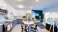 This contemporary single-floor residence offers a thoughtfully designed open-concept layout that seamlessly connects the kitchen, dining, and living areas. The kitchen is a standout feature, outfitted with high-gloss white upper cabinets, textured gray lower cabinetry, a classic subway tile backsplash, stainless steel appliances, and light hardwood-style flooring. A round marble-topped dining table anchors the dining space, creating an elegant yet functional centerpiece.

The living area is bright and inviting, highlighted by a bold teal accent wall and French doors that open directly onto a private balcony. The balcony offers serene treetop views, making it an ideal spot for outdoor relaxation. The bedroom is a peaceful retreat, featuring large windows with abundant natural light, plush carpeting, and access to a generously sized walk-in closet with full hanging rail systems.

The bathroom is clean and modern, showcasing a wood-toned vanity with ample storage, a large mirror, white countertops, and a striking penny-tile floor. A dedicated in-unit laundry room with a full-size washer and dryer adds everyday convenience. Throughout the residence, the design strikes a balance between contemporary style and practical comfort, creating a cohesive and welcoming living environment.