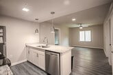Located at 3200 W Broad Street in Richmond, Virginia, this single-floor unit offers a thoughtfully designed layout with modern finishes throughout. The open-concept living and dining area features warm hardwood-style flooring and a ceiling fan, creating a comfortable, well-ventilated space filled with natural light from large sliding windows that offer views of the surrounding neighborhood.

The kitchen is outfitted with stainless steel appliances, including a refrigerator, electric range, and over-the-range microwave, complemented by white cabinetry, granite-style countertops, a classic white subway tile backsplash, and pendant lighting over a breakfast bar — ideal for both cooking and casual dining.

The bedrooms continue the hardwood-style flooring and are equipped with ceiling fans. One bedroom features a generous walk-in closet with built-in shelving and multiple hanging rods, providing ample and well-organized storage. The bathrooms are finished with light neutral tile flooring and include a tub-shower combination with grab bars for added accessibility. A stacked in-unit washer and dryer adds everyday convenience. The overall palette of soft neutral tones and clean architectural lines gives the space a fresh, modern, and functional ambiance.