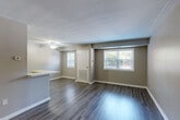 Located at 3900 Gateway Drive in Philadelphia, PA, this one-bedroom, one-bathroom unit offers a well-organized single-floor layout designed for comfortable everyday living. The open living and dining area is finished with durable dark wood-style flooring and features multiple windows that invite natural light throughout the space. A ceiling fan adds practicality to the living area, while neutral taupe walls create a clean, cohesive aesthetic.

The kitchen is a standout feature, equipped with rich dark cabinetry, light quartz countertops, a tile backsplash, and black appliances including a refrigerator, gas range, and built-in microwave. A white peninsula with an integrated sink provides additional prep space and naturally defines the boundary between the kitchen and living areas.

The bedroom is carpeted for warmth and comfort, offering a quiet retreat with a window overlooking greenery. It includes two sliding-door closets, providing generous storage. A hallway connects the main living spaces to the bathroom and a utility room, adding functional flow to the layout.

The bathroom is tastefully finished with a soaking tub surrounded by white subway tile and accented by a decorative mosaic border in warm earth tones. Together, these details reflect a thoughtfully updated interior with a modern yet practical character.