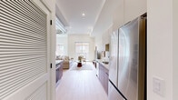This well-designed one-bedroom, one-bathroom unit at 1818 N 53rd St in Philadelphia offers a thoughtfully planned open-concept layout across a single floor. The living area is bright and airy, featuring light wood flooring, recessed lighting, and an exposed industrial-style ductwork element that adds an urban, loft-inspired character to the space. Large sliding glass doors lead to an outdoor area, allowing natural light to fill the room and providing views of the surrounding neighborhood. The kitchen flows seamlessly from the living area, showcasing warm walnut-toned cabinetry, patterned tile backsplash, stainless steel appliances, and clean white upper cabinets — a functional yet stylish design. The bedroom is comfortably proportioned, featuring soaring ceilings, light wood floors, a large sliding closet with built-in shelving, and a generous window that draws in natural light and neighborhood views. The bathroom is finished to a high standard, with polished marble-look tile flooring, a sleek vanity with dark hardware accents, a full tub-shower combination enclosed by black-framed glass sliding doors, and warm wood-toned wall tile in the shower surround. Throughout the unit, the consistent use of neutral tones, modern fixtures, and quality materials creates a cohesive and contemporary living environment.