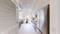 This well-designed one-bedroom, one-bathroom unit at 1818 N 53rd St in Philadelphia offers a thoughtfully planned open-concept layout across a single floor. The living area is bright and airy, featuring light wood flooring, recessed lighting, and an exposed industrial-style ductwork element that adds an urban, loft-inspired character to the space. Large sliding glass doors lead to an outdoor area, allowing natural light to fill the room and providing views of the surrounding neighborhood. The kitchen flows seamlessly from the living area, showcasing warm walnut-toned cabinetry, patterned tile backsplash, stainless steel appliances, and clean white upper cabinets — a functional yet stylish design. The bedroom is comfortably proportioned, featuring soaring ceilings, light wood floors, a large sliding closet with built-in shelving, and a generous window that draws in natural light and neighborhood views. The bathroom is finished to a high standard, with polished marble-look tile flooring, a sleek vanity with dark hardware accents, a full tub-shower combination enclosed by black-framed glass sliding doors, and warm wood-toned wall tile in the shower surround. Throughout the unit, the consistent use of neutral tones, modern fixtures, and quality materials creates a cohesive and contemporary living environment.