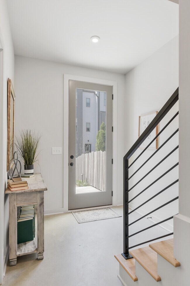 Entrada luminosa y acogedora con acabados elegantes y detalles de barandilla modernos. - 358 E Village Ln