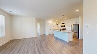 Located at 200 Aycock Avenue in Monroe, GA, this well-appointed 3-bedroom, 2-bathroom single-story home offers a thoughtfully designed open-concept layout. The kitchen serves as the centerpiece of the home, boasting crisp white shaker cabinetry with matte black hardware, granite countertops, a large central island with an undermount sink, stainless steel appliances, and striking pendant lighting overhead. Recessed lighting and a clean white tile backsplash complete the polished look. The kitchen flows seamlessly into the spacious living area, where light wood-look flooring, neutral walls, and abundant natural light from multiple windows create a bright and airy ambiance. A ceiling fan and an exterior door leading to a private outdoor area add comfort and functionality to the living space. Each of the three bedrooms is generously sized, featuring the same wood-look flooring, ceiling fans, and large windows that invite natural light and outdoor views. The primary bedroom is complemented by a well-equipped en-suite bathroom with a dual-sink granite vanity, white cabinetry, and a walk-in closet with built-in shelving and hanging rods. Three dedicated closets throughout the home provide ample storage for everyday living.