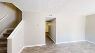 Located in Marietta, GA, this two-story home offers five bedrooms and two full bathrooms across a thoughtfully arranged floor plan. The main level features a living room with wood-look plank flooring, neutral-toned walls, and a closet with bifold doors near the entry. A staircase connects the two floors, adding to the home's functional flow. The kitchen stands out with rich cherry-toned cabinetry, granite-look countertops, a U-shaped layout, and black appliances including a gas range and refrigerator, all set on wood-look flooring. Both bathrooms are consistently finished with dark wood vanities, granite-look countertops, and tiled tub-shower combinations. The bedrooms are carpeted for comfort, with neutral walls and individual closets — several featuring wire-rack shelving for organized storage. The spacious primary bedroom includes a walk-in closet with dual wire shelving rails. Upper-level bedrooms benefit from natural light through windows, while textured ceilings are present throughout the home. The consistent use of warm neutrals and coordinated finishes creates a cohesive, move-in-ready atmosphere suited for a variety of living arrangements.