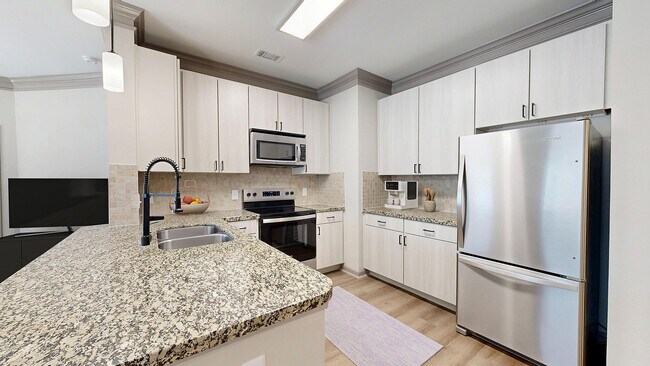 Cocina recientemente renovada con encimeras de granito - Avenues at Craig Ranch Apartments