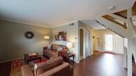 University Village in Carbondale, Illinois presents a thoughtfully designed two-bedroom, two-bathroom residence spread across two floors. The main living area features rich hardwood flooring and crown molding, creating a warm and inviting atmosphere. The open layout connects the living room to the entryway, providing a sense of spaciousness and ease of movement throughout the main level.

The kitchen is well-appointed with white cabinetry, granite-style countertops, and black appliances including a refrigerator, range, microwave, and dishwasher. Hardwood flooring continues through the kitchen, adding to the cohesive design of the main level.

Both bedrooms are carpeted and offer a comfortable, quiet retreat. Each room features a ceiling fan, ample natural light from windows, and sufficient space for a bed, dresser, and a dedicated study area — ideal for students or working professionals. Walk-in closet access is visible in at least one bedroom.

The two full bathrooms each include a tub-shower combination, tile flooring, and clean white finishes, providing functional and private spaces for residents.

Overall, University Village offers a practical and comfortable two-floor layout well-suited to student living near Southern Illinois University, combining functional design with a welcoming residential feel.
