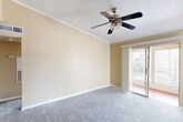 Located at 15530 Ella Blvd in Houston, TX, this single-story, one-bedroom, two-bathroom unit offers a well-organized layout across a comfortable footprint. The living room serves as the heart of the home, featuring elegant crown molding, a ceiling fan with light fixture, plush wall-to-wall carpet, and a striking white-paneled wood-burning fireplace as the focal point. Natural light filters in through a side window, while a sliding glass door provides access to an outdoor balcony or patio area, enhancing the sense of openness. The dining area flows naturally from the living space, maintaining the same warm, neutral color palette. The galley-style kitchen is equipped with white cabinetry, dark granite-style countertops, a double stainless steel sink, and black appliances, complemented by rich hardwood-style flooring. A closet just off the kitchen offers additional storage. The spacious primary bedroom features soft carpet, a generous walk-in closet with built-in shelving, and a window that brings in natural light. A hallway connects the rooms efficiently, with two bathrooms and additional closets providing ample storage throughout. The overall ambiance is clean, functional, and inviting.