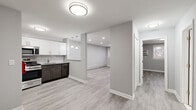 Located at 90 Lupton Lane in Haledon, NJ, this thoughtfully updated one-bedroom, one-bathroom unit offers a well-organized layout across a single floor. Light-toned luxury vinyl plank flooring runs throughout, creating a clean and cohesive aesthetic complemented by soft gray walls and crisp white trim.

The kitchen is a standout feature, equipped with stainless steel appliances including a gas range, over-the-range microwave, and full-size refrigerator. Two-tone cabinetry pairs white upper shaker cabinets with dark lower cabinets against a classic white subway tile backsplash. A pass-through counter with pendant lighting connects the kitchen to the dining area, enhancing the open feel of the space.

The living room benefits from recessed lighting and windows that bring in natural light, while the separate dining area provides a defined space for meals. The spacious bedroom features a wall-mounted AC unit, baseboard heating, and a window with outdoor views, offering a comfortable and functional retreat. Three closets provide ample storage throughout the unit.

The bathroom is finished with large-format white wall tiles surrounding a soaking tub and shower combo, complemented by tile flooring and brushed gold fixtures. A pantry rounds out the unit's practical offerings, making this a well-appointed and move-in-ready space.