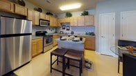 Located at 8650 Barbara Ann Way in Delmar, Maryland, this single-floor residence offers a thoughtfully designed layout with a cohesive, neutral color palette and comfortable finishes throughout. The kitchen is a functional centerpiece, featuring warm honey-toned cabinetry, granite-style countertops, stainless steel appliances including a range and dishwasher, and a peninsula island with seating — ideal for casual dining. A ceiling-mounted light fixture provides bright, even illumination across the space. The living room exudes comfort and style, highlighted by a classic fireplace with a painted mantel, crown molding, plush carpet flooring, and a glass-paneled exterior door that invites natural light. The bedroom features soft carpeting, a generous closet, and neutral wall tones that create a calm retreat. A vanity area with a round mirror and dedicated dressing space adds an elegant touch. Bathrooms are finished with wood-toned cabinetry, light countertops, and clean tile flooring, offering a serene and functional environment. Throughout the home, consistent soft gray and beige tones, plush carpet in living and sleeping areas, and smooth transitions between rooms contribute to a warm, welcoming ambiance well-suited for everyday living.