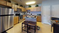 Located at 8650 Barbara Ann Way in Delmar, Maryland, this single-floor residence offers a thoughtfully designed layout with a cohesive, neutral color palette and comfortable finishes throughout. The kitchen is a functional centerpiece, featuring warm honey-toned cabinetry, granite-style countertops, stainless steel appliances including a range and dishwasher, and a peninsula island with seating — ideal for casual dining. A ceiling-mounted light fixture provides bright, even illumination across the space. The living room exudes comfort and style, highlighted by a classic fireplace with a painted mantel, crown molding, plush carpet flooring, and a glass-paneled exterior door that invites natural light. The bedroom features soft carpeting, a generous closet, and neutral wall tones that create a calm retreat. A vanity area with a round mirror and dedicated dressing space adds an elegant touch. Bathrooms are finished with wood-toned cabinetry, light countertops, and clean tile flooring, offering a serene and functional environment. Throughout the home, consistent soft gray and beige tones, plush carpet in living and sleeping areas, and smooth transitions between rooms contribute to a warm, welcoming ambiance well-suited for everyday living.