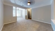 Located at 3115 Preston Pointe Way in Cumming, Georgia, this single-floor home offers a well-designed layout with a clean, neutral aesthetic throughout. The open-concept living and dining area is defined by elegant decorative columns and finished with crown molding, plush carpeting, and ceiling fans. Natural light filters in through blinded windows, creating a bright and welcoming atmosphere.

The kitchen is a functional highlight, featuring white shaker-style cabinetry, light quartz countertops, a dark subway tile backsplash, and a full suite of stainless steel appliances including a range, microwave, dishwasher, and refrigerator. A peninsula with a built-in sink and pendant lighting above the dining area adds both style and practicality.

The bedrooms are generously sized, each with plush carpet, ceiling fans, and access to closet space. The primary bedroom connects to a private bathroom and a walk-in closet. The full bathroom includes a white vanity, wood-look tile flooring, and a tub-shower combination. A separate half bath with a pedestal sink serves guests conveniently.

A dedicated laundry room houses a full-size washer and dryer, adding everyday convenience. Wood-look flooring runs through the wet areas, complementing the home's cohesive, modern-neutral design.