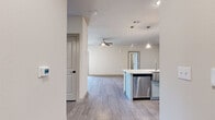 This well-designed 2-bedroom, 2-bathroom home in Georgetown, TX offers a thoughtfully planned single-floor layout with modern finishes throughout. The open-concept living and kitchen area serves as the heart of the home, showcasing wood-look flooring, neutral warm tones, and a ceiling fan that enhances the airy feel. The kitchen is a standout feature, equipped with stainless steel appliances including a French door refrigerator and dishwasher, gray shaker-style cabinetry, a herringbone tile backsplash, and a generous island with a white countertop and elegant pendant lighting overhead. The living area flows naturally from the kitchen, bathed in natural light from windows overlooking the outdoors, with access to a private balcony. Both bedrooms are comfortably sized, featuring wood-look flooring, ceiling fans, and ample natural light from large windows with blinds. Each bedroom is paired with a dedicated closet; the primary bedroom includes a spacious walk-in closet with built-in shelving and hanging rods. The two bathrooms are finished with sage-toned shaker vanities, white countertops, framed mirrors, and glass-enclosed showers. Two dedicated closets add further storage convenience throughout the home.