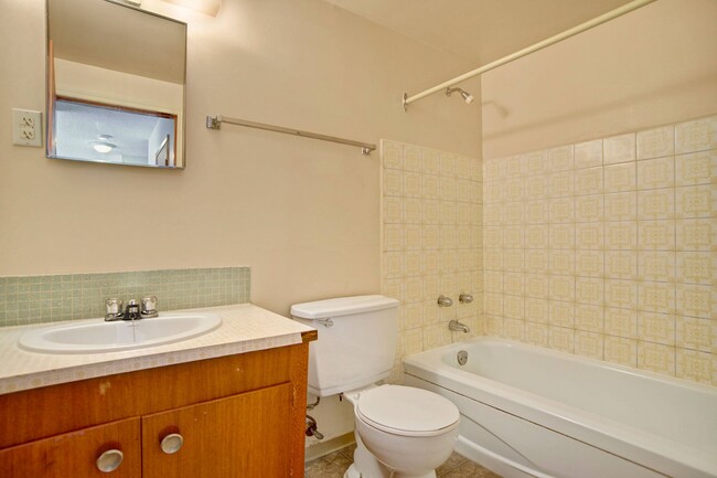 A bathroom with shower and tub with a mirror above the sink - Alderview