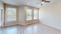 Located at 701 N Frazier St in Conroe, TX, this single-story, 2-bedroom, 3-bathroom home offers a well-designed layout with quality finishes throughout. The open living room welcomes abundant natural light through multiple large windows, complemented by recessed lighting, a ceiling fan, and easy-to-maintain luxury vinyl plank flooring. The kitchen is a standout feature, boasting rich dark cabinetry, striking gold-veined granite countertops, a peninsula with a built-in sink, and black appliances including a range, microwave, and refrigerator. The spacious primary bedroom includes plush carpeting, a ceiling fan, and direct access to an en-suite bathroom featuring dark vanity cabinetry with granite countertops. The additional bedroom is cozy with carpeted floors and a bright window. Three bathrooms serve the home, one of which includes a tiled tub-shower combination with hardwood-style flooring and a marble-top vanity. A dedicated walk-in closet with double hanging rods and hardwood-style flooring adds practical storage. The home also includes a laundry area, hallway, and recessed lighting throughout, creating a clean and modern ambiance.