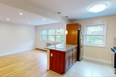 Located at 653 Pompton Avenue in Cedar Grove, NJ, this well-appointed one-bedroom, one-bathroom residence offers a thoughtfully designed single-floor layout. The open-concept kitchen and living area serves as the heart of the home, where light hardwood flooring flows seamlessly throughout. The kitchen is equipped with warm cherry wood cabinetry, granite countertops, stainless steel appliances including a gas range, microwave, and refrigerator, and a tile backsplash. A peninsula with pendant lighting provides additional workspace and separates the kitchen from the living area, which is brightened by multiple windows framing lush greenery views. Recessed lighting and a ceiling fan add to the functional ambiance of the living space. The bedroom is a comfortable retreat featuring a built-in closet with shelving, a wall-unit HVAC system, baseboard heating, and a window overlooking the outdoors. The bathroom includes a full soaking tub with elegant large-format neutral tile surround and a window for natural light. A hallway connects all rooms efficiently, completing this clean and practical layout ideal for comfortable everyday living.