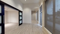 Located at 4440 Twain Ave in San Diego, Retail #101 is a single-level suite offering a contemporary and versatile layout suited for a variety of uses. The space features light-toned luxury vinyl plank flooring throughout the main areas, crisp white walls, and recessed lighting that creates a clean, bright atmosphere.

The open main area is generously proportioned, with large windows fitted with roller shades that allow for controlled natural light while maintaining privacy. A sleek sliding door with frosted glass panels adds a modern architectural detail and provides flexible room division. The connected rooms flow naturally, offering adaptable configurations.

The kitchen is well-appointed with rich, dark wood-grain cabinetry extending to the ceiling for ample storage, white quartz countertops, a textured tile backsplash, and a full suite of stainless steel appliances including a refrigerator, range, microwave, and dishwasher. Track lighting above adds both function and style.

The bathroom includes a wood-grain vanity with a white countertop, a tub-shower combination with white tile surround, and a stacked washer and dryer unit for added convenience. A separate ADA-compliant bathroom features grab bars, an open vanity, and a spacious layout. The bedroom area is carpeted and includes a sliding closet.