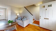 Located at 3 Smith Dr in East Hartford, CT, this two-bedroom, one-bathroom home is thoughtfully arranged across two floors. The main level features a bright living room with warm hardwood flooring, large windows that invite natural light, and a staircase that connects to the upper level. Adjacent to the living room, the dining area offers a welcoming space with wood-style flooring and a door providing access to the outdoors. The kitchen is well-equipped, featuring rich dark wood cabinetry, white countertops, a stainless steel gas range with overhead ventilation, and a stainless steel sink — a functional and attractive cooking space. Upstairs, the primary bedroom is comfortably sized, showcasing hardwood floors, natural wood furniture, and windows overlooking the neighborhood. The second bedroom features hardwood floors, neutral tones, and a built-in closet. The full bathroom is clean and practical, complete with a tub-shower combination, a dark wood vanity, and tile flooring. Throughout the home, a neutral color palette, hardwood floors on the upper level, and consistent natural light create a cohesive and inviting atmosphere suited for everyday living.