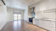 This efficiently designed one-bedroom, one-bathroom unit at 1710 R St in Sacramento's vibrant Midtown neighborhood offers a clean, modern aesthetic throughout. The open-concept layout seamlessly connects the kitchen, dining, and living areas into one cohesive space, maximizing functionality and flow.

The kitchen is a standout feature, outfitted with sleek white cabinetry extending to the ceiling, a stainless steel range with a bold overhead vent hood, a stainless steel backsplash, a dishwasher, and a full-size refrigerator — all set against crisp white countertops. Wood-style plank flooring runs continuously throughout the unit, lending warmth and visual continuity.

The living area is bathed in natural light, courtesy of a set of glass doors with roller shades that open to an outdoor view — creating an airy, bright atmosphere. The bedroom is a comfortable, well-proportioned room with a natural light-filled window and a dedicated closet for storage.

The bathroom features a wall-mounted white vanity with a rectangular basin sink, a large mirror with overhead lighting, and matching wood-style flooring. In-unit laundry adds everyday convenience. With its modern finishes and thoughtful layout, this unit offers a polished urban living experience in the heart of Sacramento.