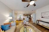 Located in Youngsville, Louisiana, this well-appointed 2-bedroom, 2-bathroom single-story home offers a thoughtfully designed open-concept layout that seamlessly connects the kitchen, dining, and living areas. The kitchen is a standout feature, boasting rich dark-walnut cabinetry, granite countertops, a large center island, stainless steel appliances, a subway tile backsplash, and pendant lighting. Wood-style flooring flows throughout the main living areas, adding warmth and continuity. The dining area is defined by an elegant chandelier and offers a welcoming space for meals. The living room is bright and comfortable, accented by a ceiling fan and natural light from large windows. Each bedroom features plush carpeting, ceiling fans, and generous natural light. The primary bedroom includes its own en-suite bathroom with granite countertops, dark cabinetry, and a full tub-shower combination. Five closets throughout the home provide exceptional storage, including walk-in options with wire shelving systems. A dedicated in-unit laundry room houses a full-size washer and dryer. A private patio rounds out this home, offering outdoor space. The clean, neutral palette and modern finishes create a cohesive and inviting ambiance throughout.